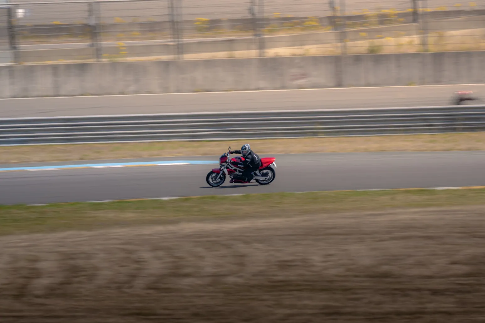 Rider on a red naked bike leaning into a corner