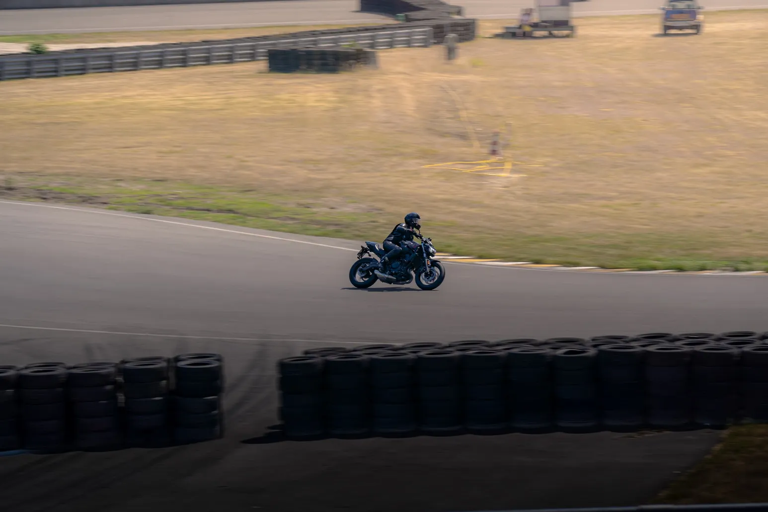 Rider on a dark naked bike in a wide left-hander