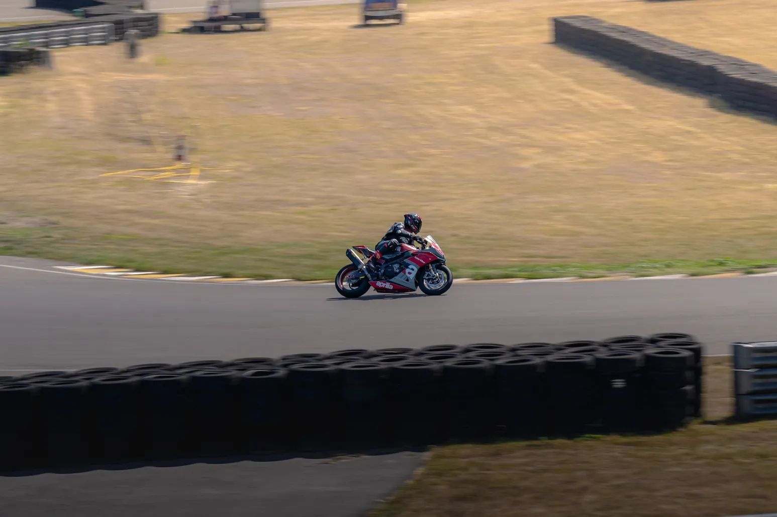 Red and white sport bike cornering, rider tucked in