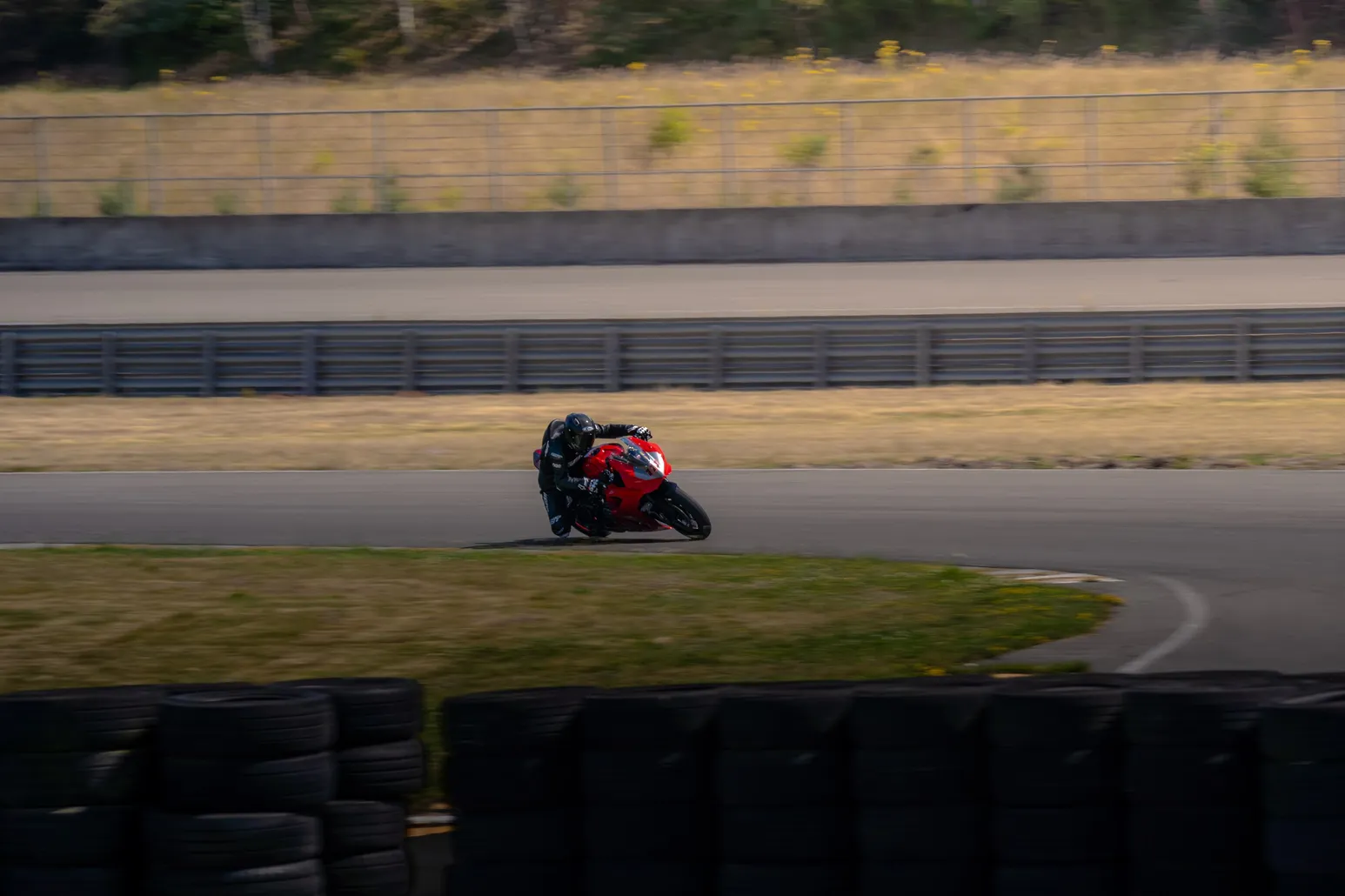 Red motorcycle leaning hard through a bend