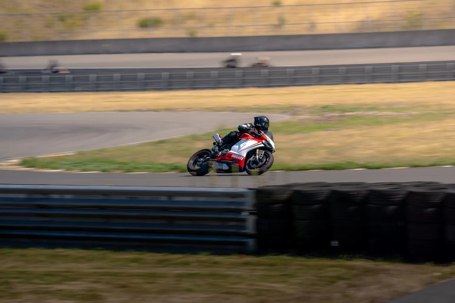 Rider on a red and white bike through the turn