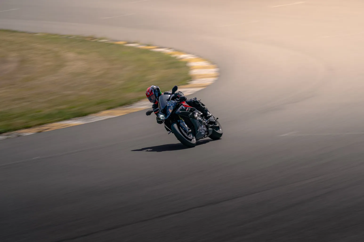 Dark sport bike in a panning shot through the bend