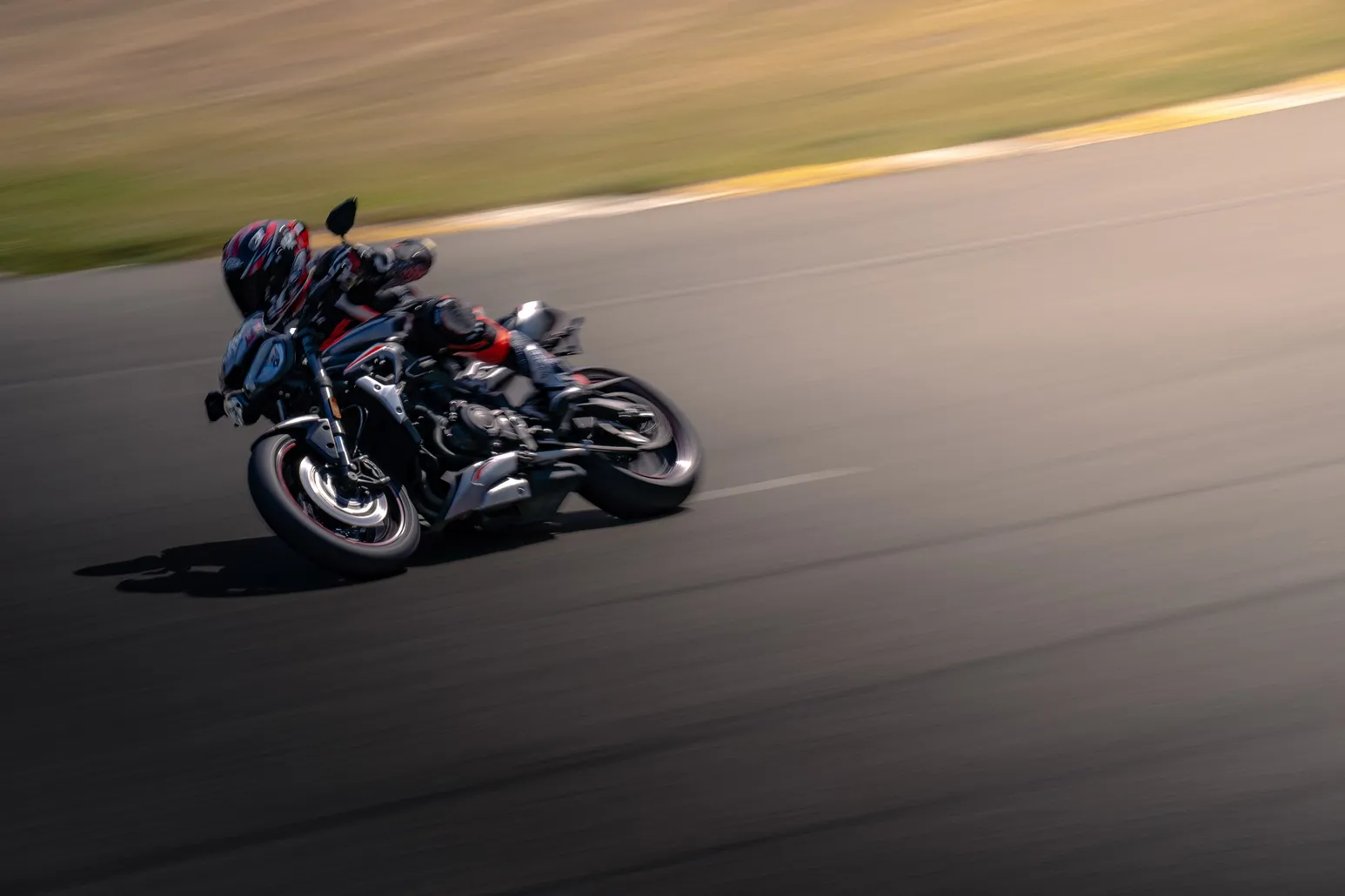 Dark naked bike at lean, close panning shot