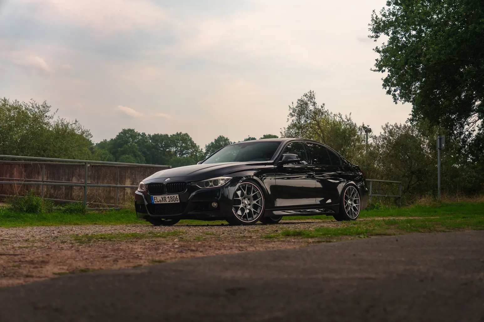 Black BMW F30 low wide shot under a cloudy sky