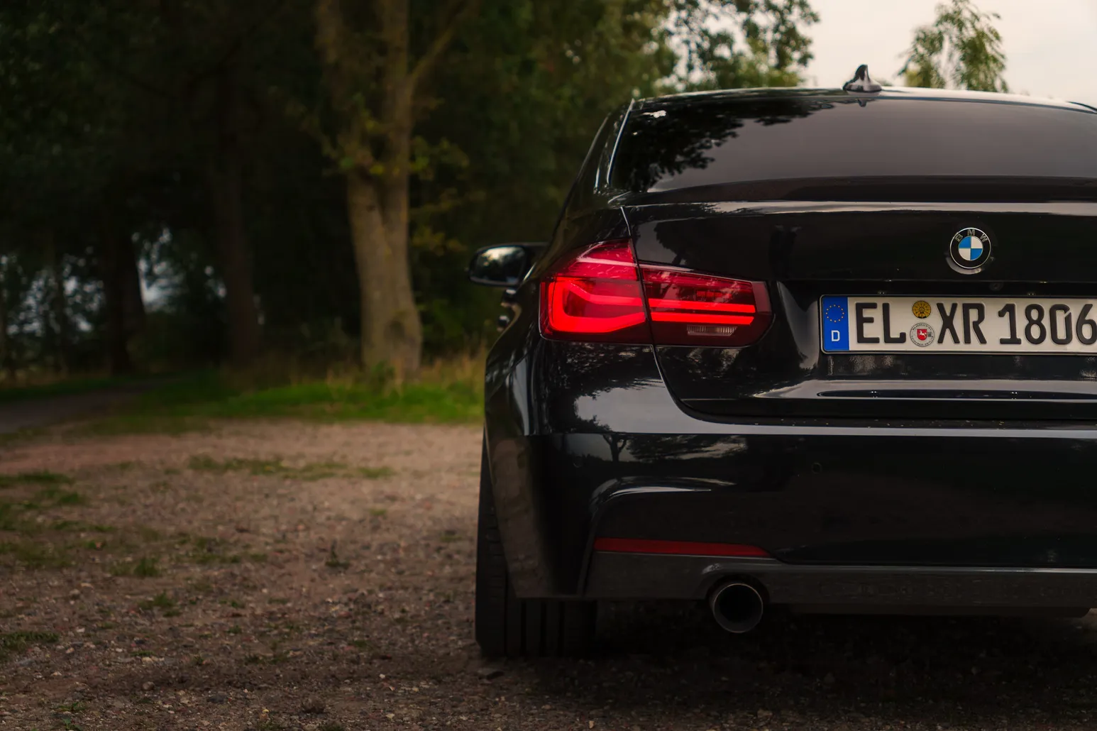 Rear quarter of the BMW F30 with lit tail lights