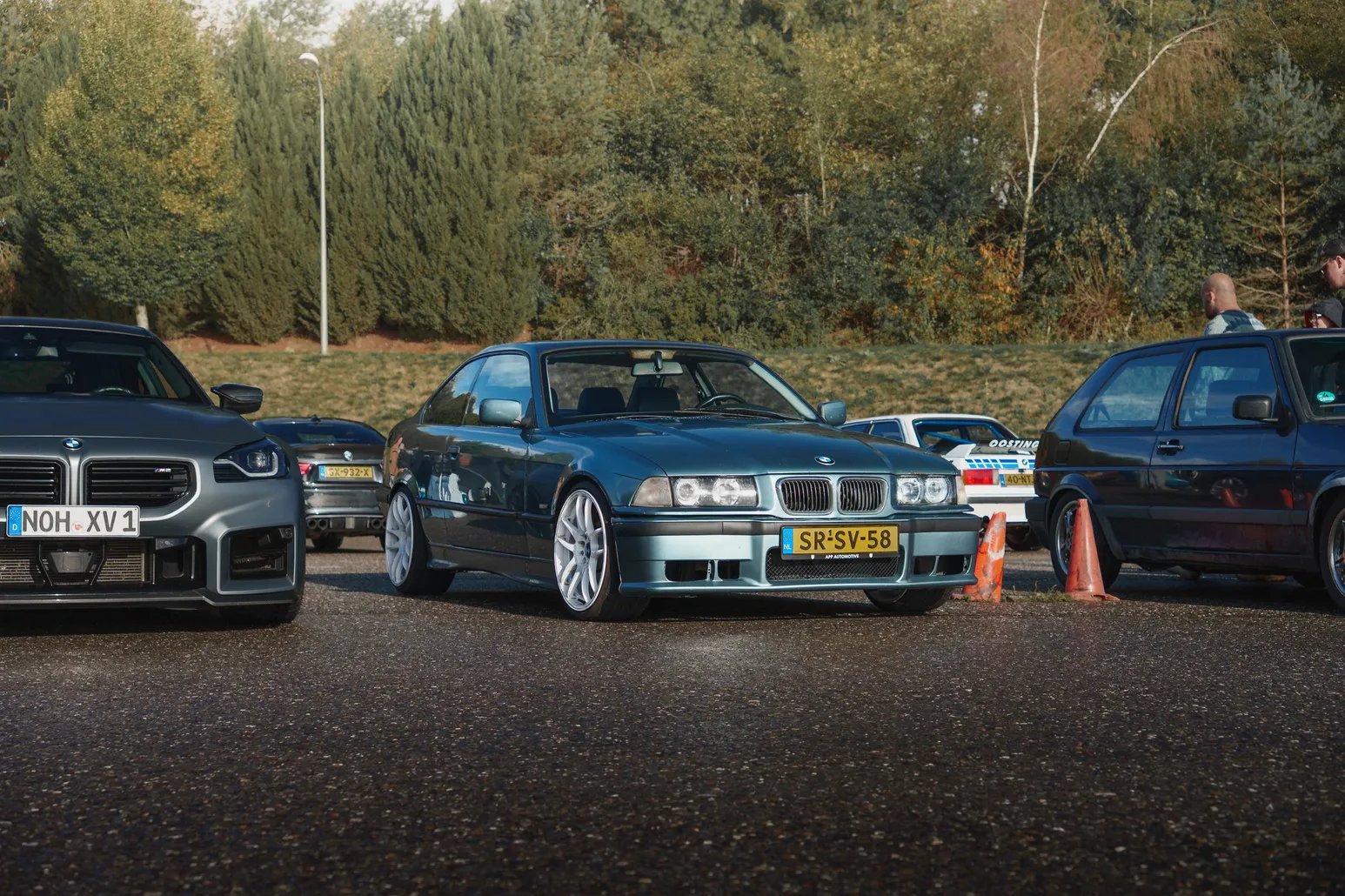 Grauer BMW E36 zwischen anderen Autos im Fahrerlager