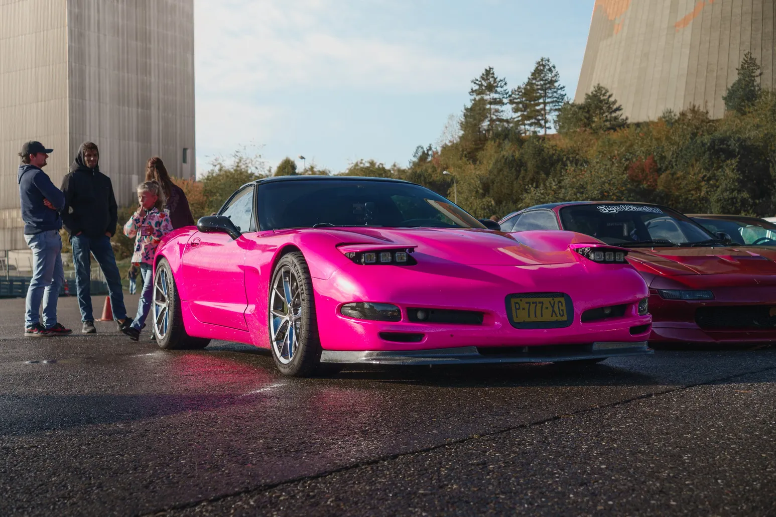 Pinke Chevrolet Corvette C5, daneben Menschen im Gespräch