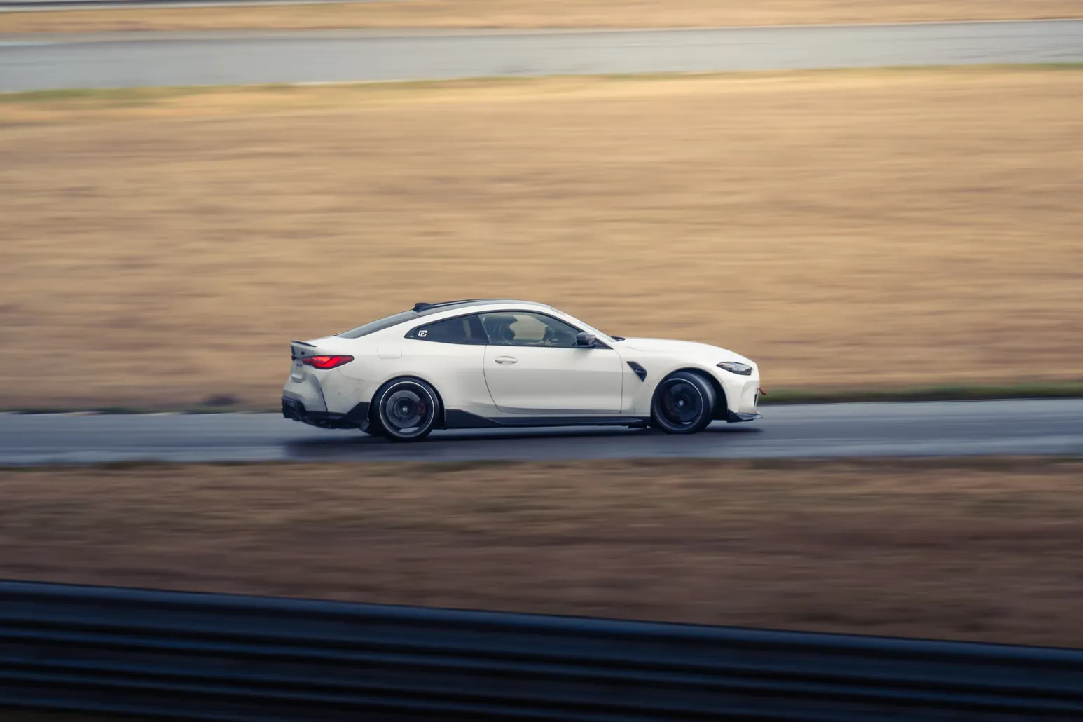White BMW M4 in a panning shot along the track