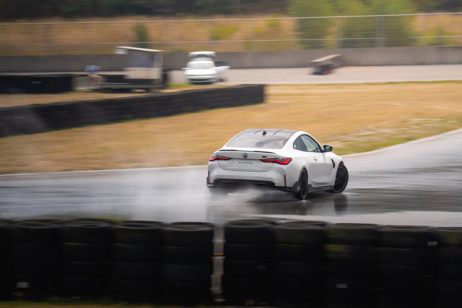 White BMW M4 drifting with spray on the wet surface