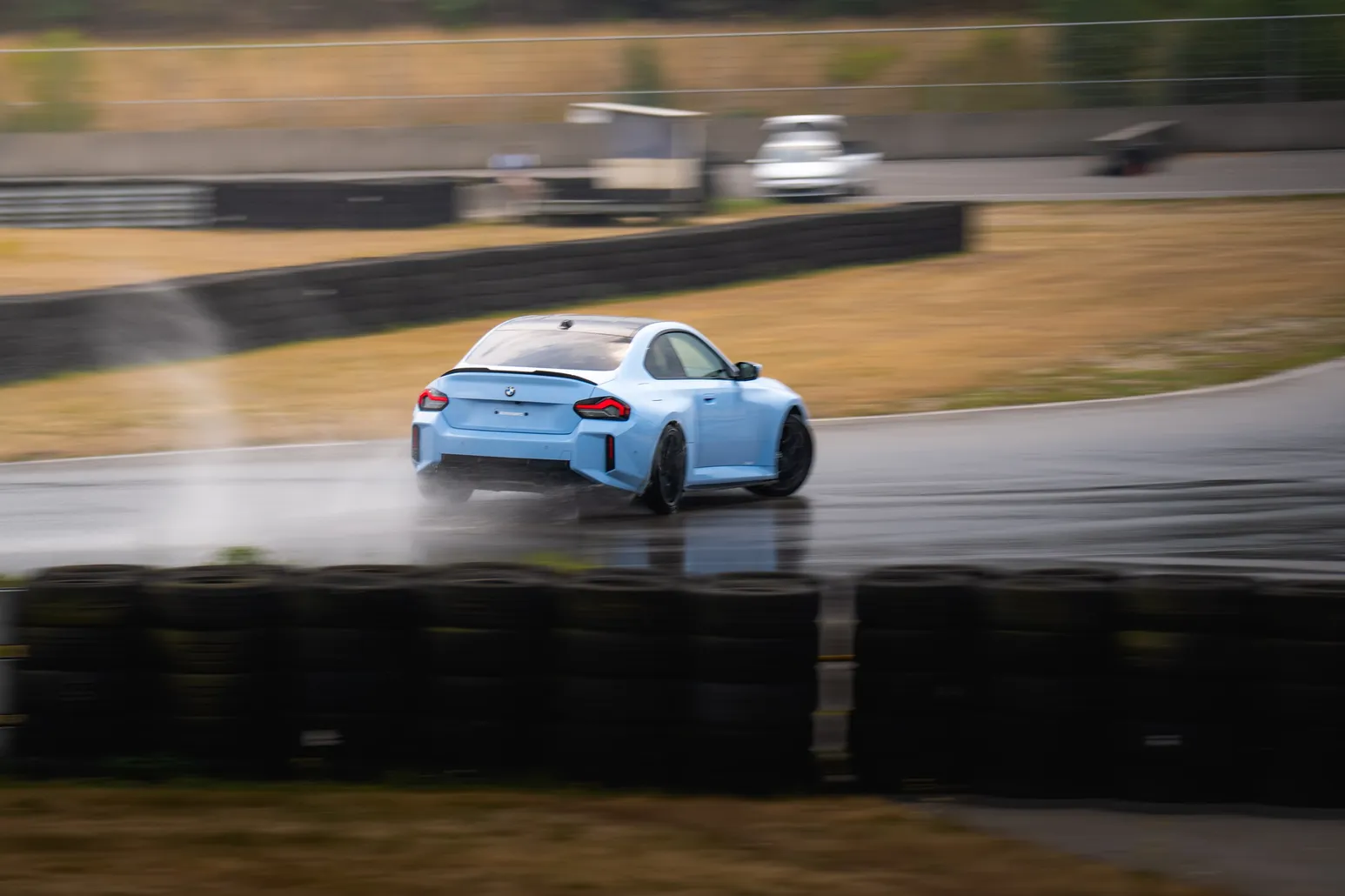 Light blue BMW M2 sliding through water spray