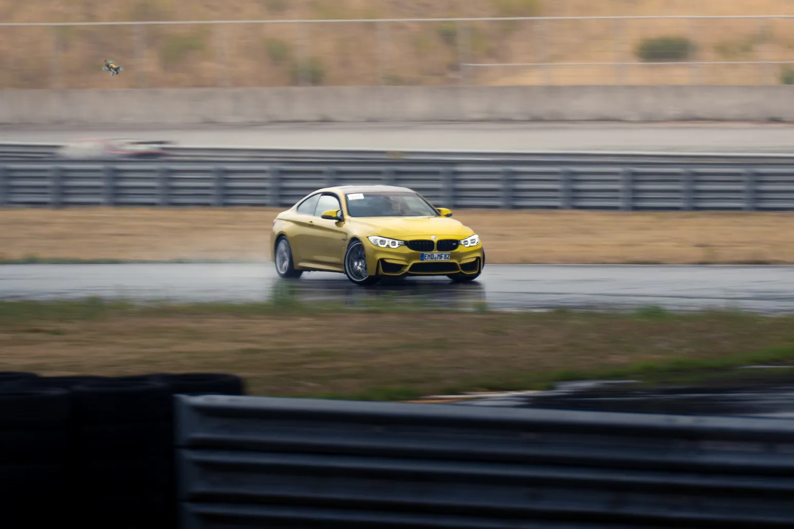Yellow BMW M4 drifting on the wet track