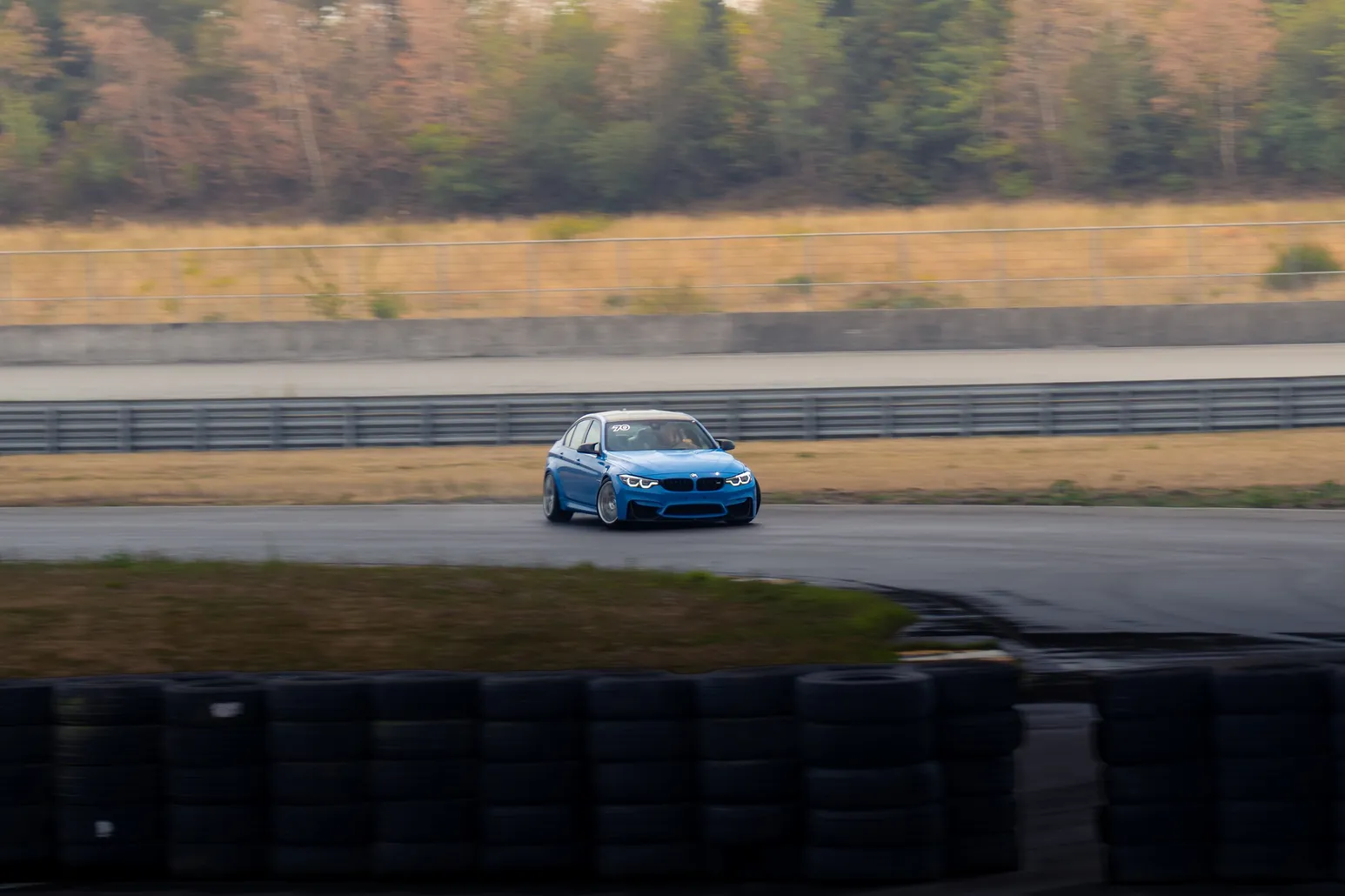 Blue BMW M3 on the far side of the track