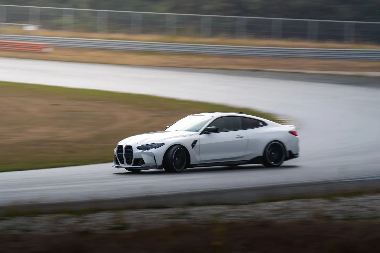 White BMW M4 drifting in a sweeping panning shot