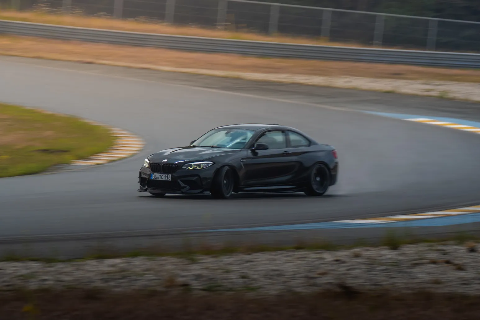 Dark grey BMW M2 drifting in a panning shot