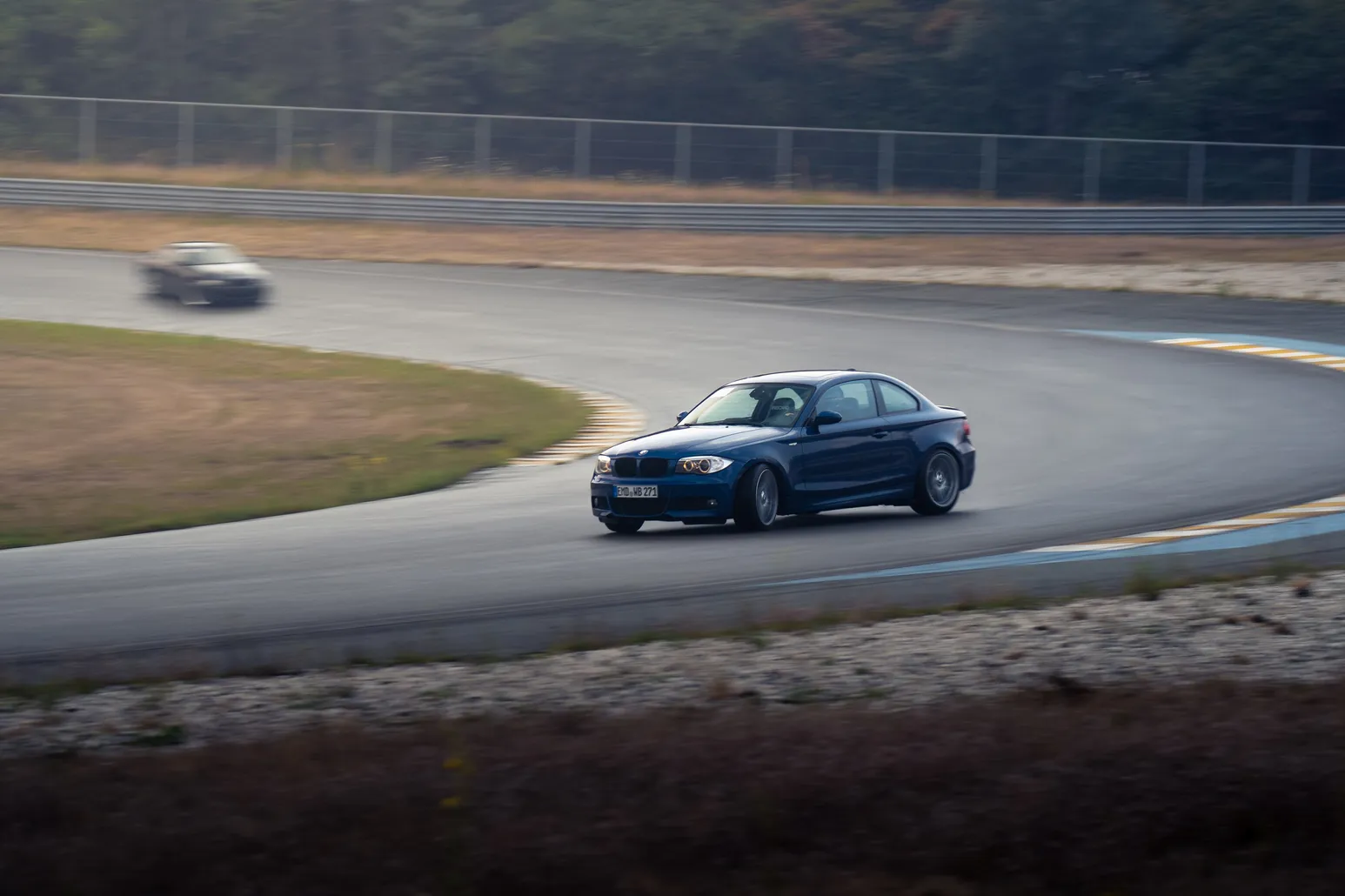 Dark blue BMW drifting with another car in the background