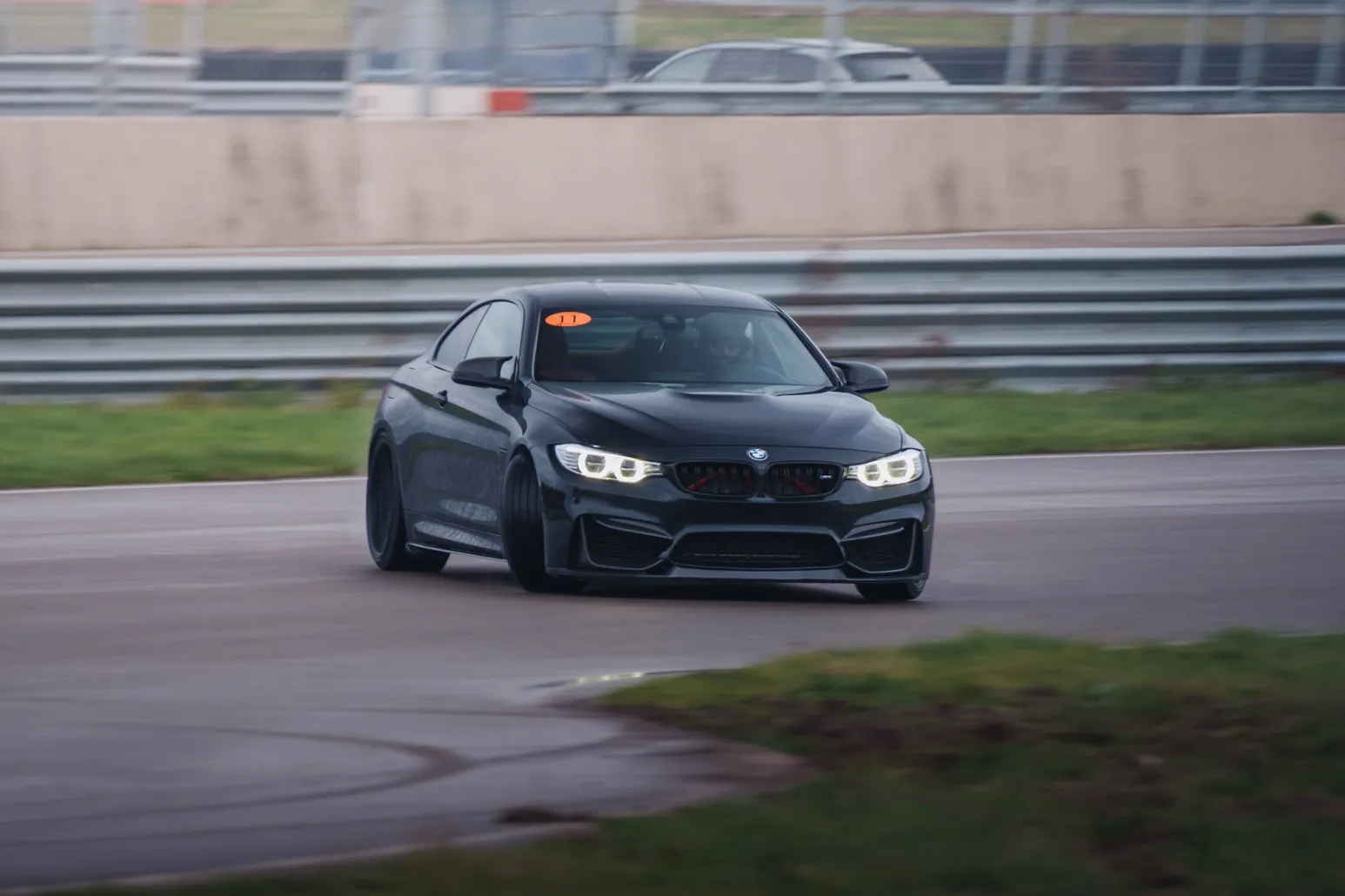 Black BMW M4 (F82) head-on with headlights on