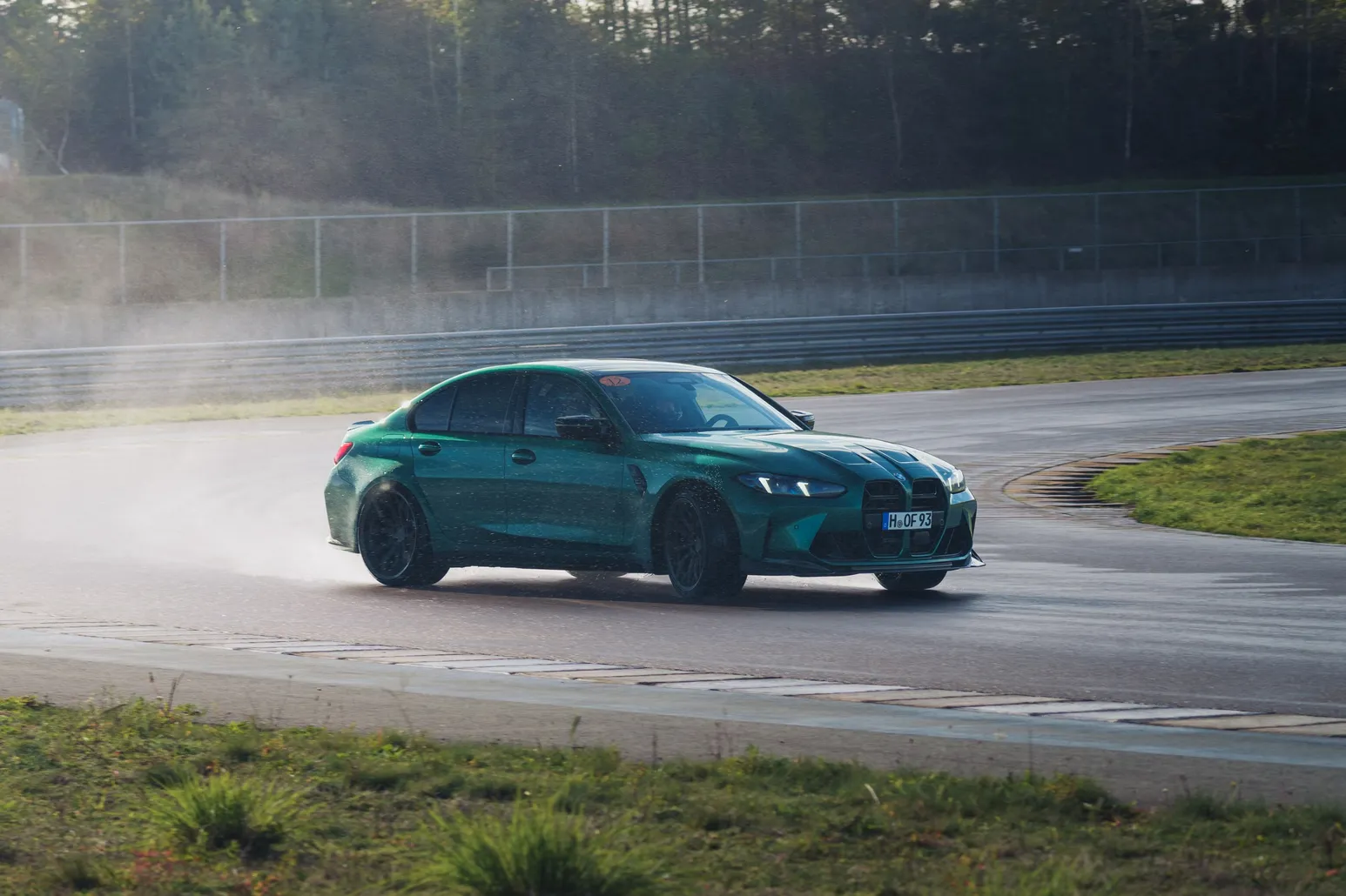 Green BMW M3 (G80) sideways with water mist