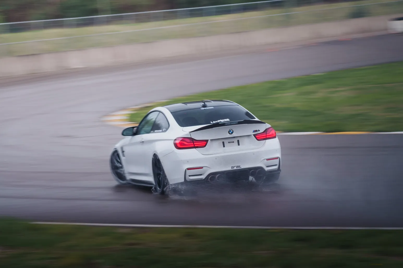 White BMW M4 (F82) from behind with spray