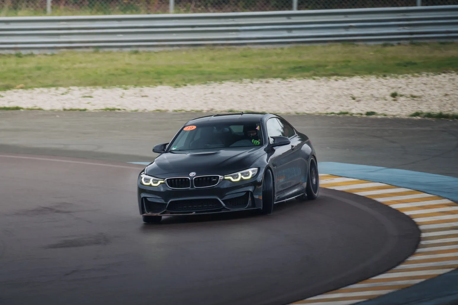 Black BMW M4 (F82) head-on over the kerbs