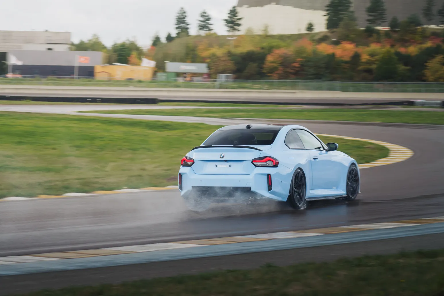 Light blue BMW M2 (G87) drifting with smoke in front of the power station