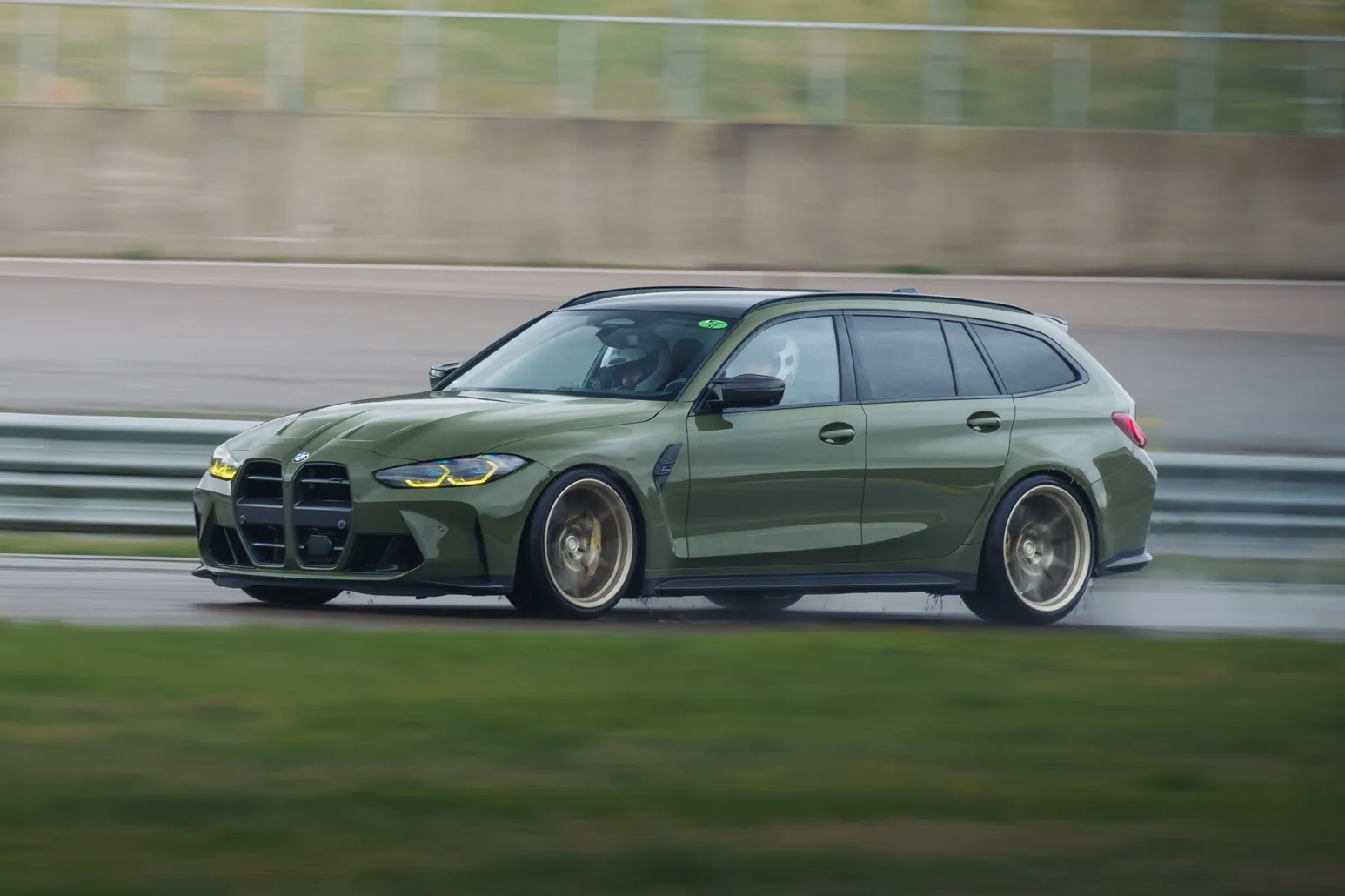 Olive green BMW M3 Touring panning shot