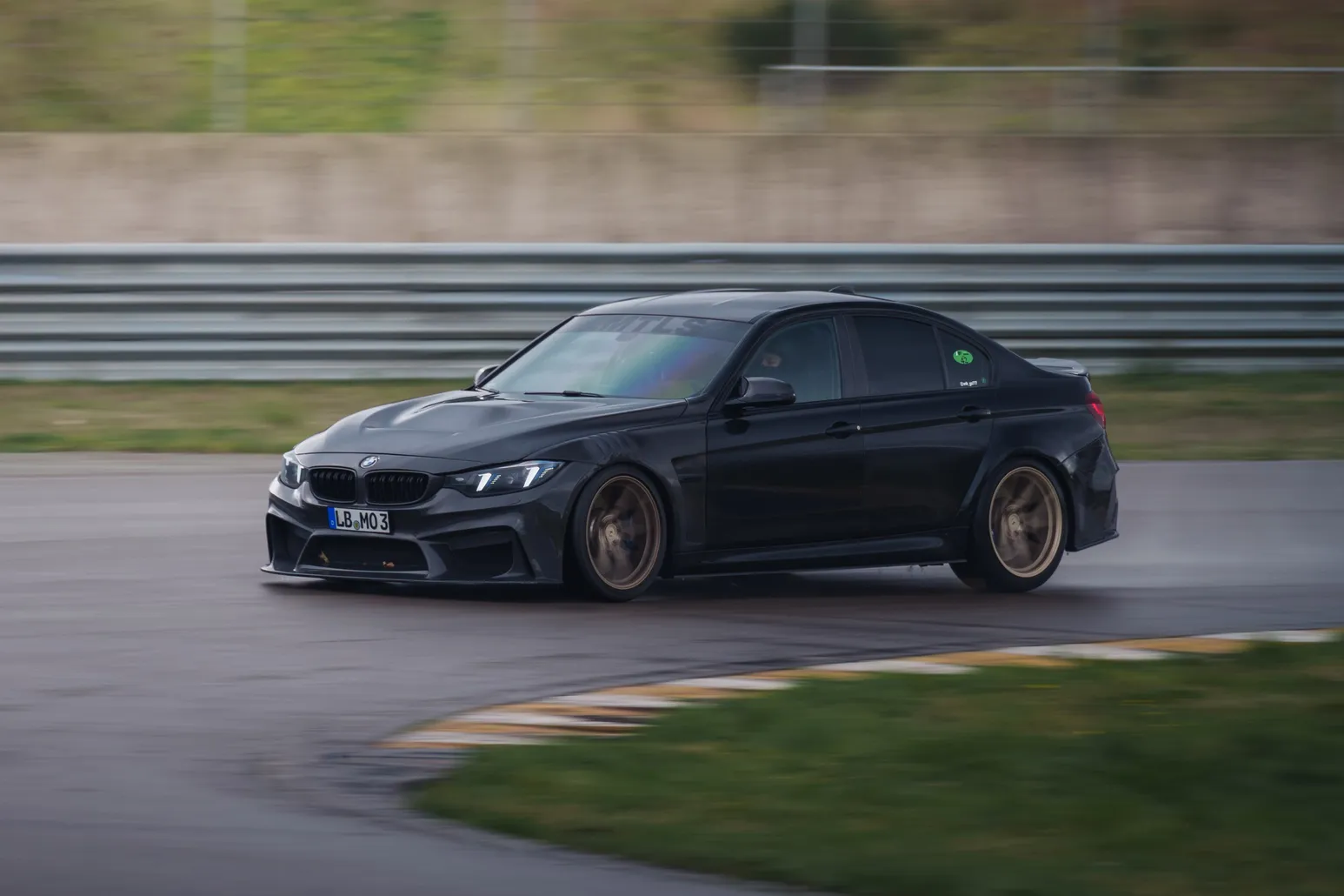 Black BMW M3 (F80) with bronze wheels in a corner