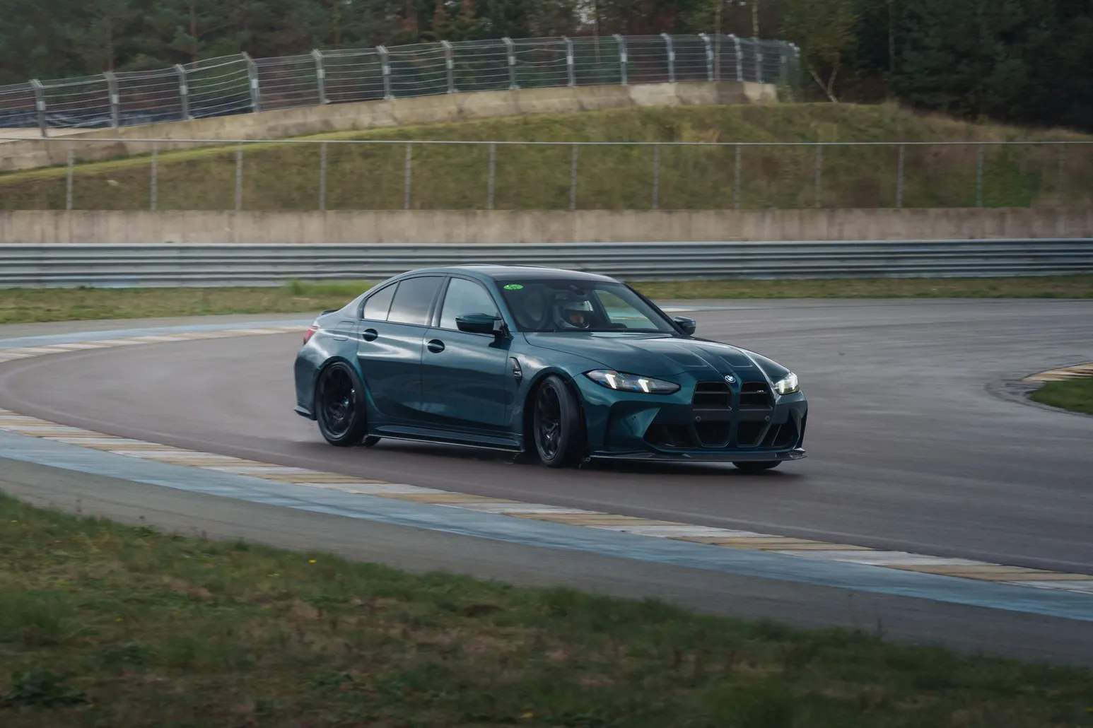 Teal BMW M3 (G80) drifting through a corner