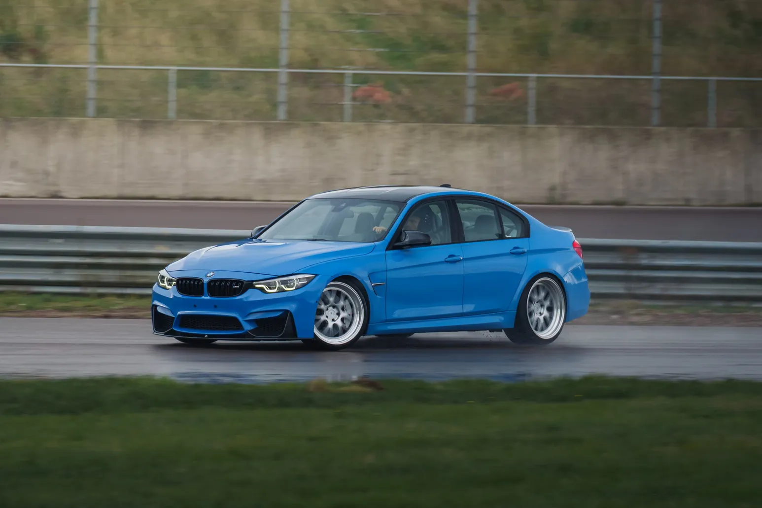 Blue BMW M3 (F80) side-on in front of the barrier