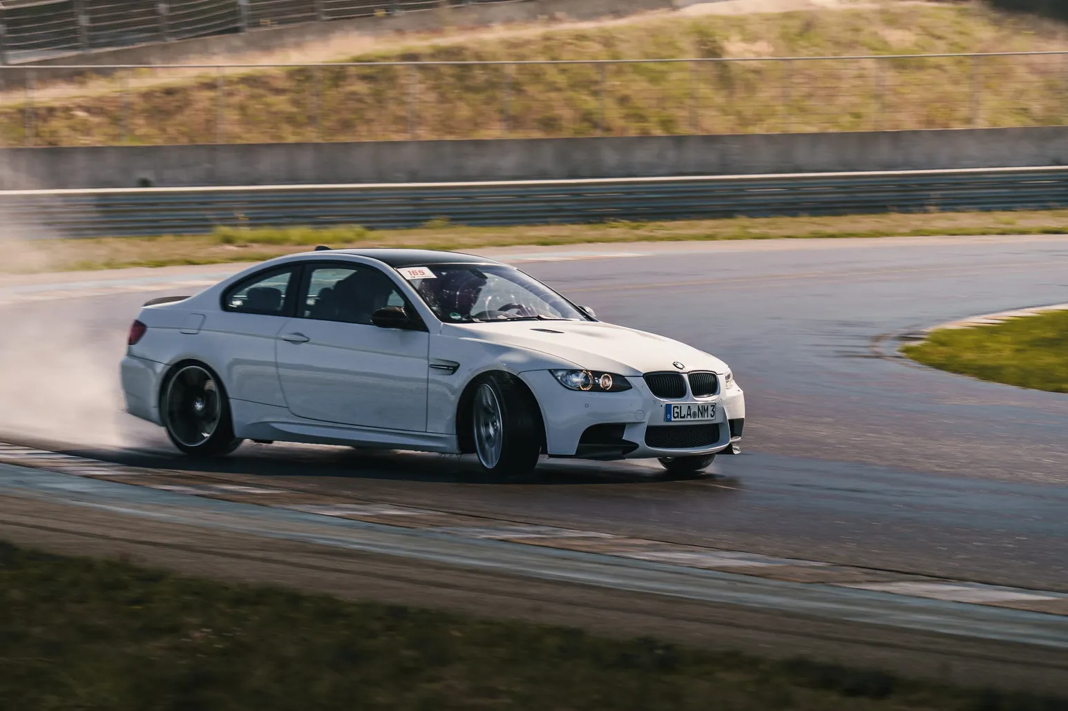 Weißer BMW E92 M3 driftet mit Reifenqualm