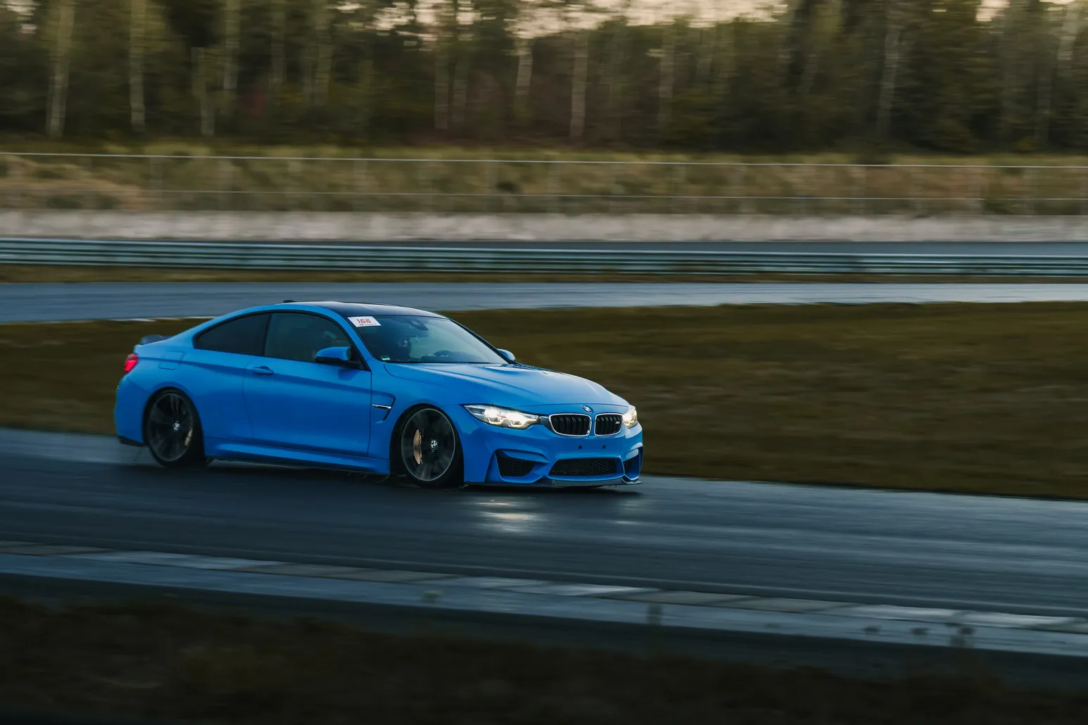 Blauer BMW M4, tiefer Mitzieher im Abendlicht
