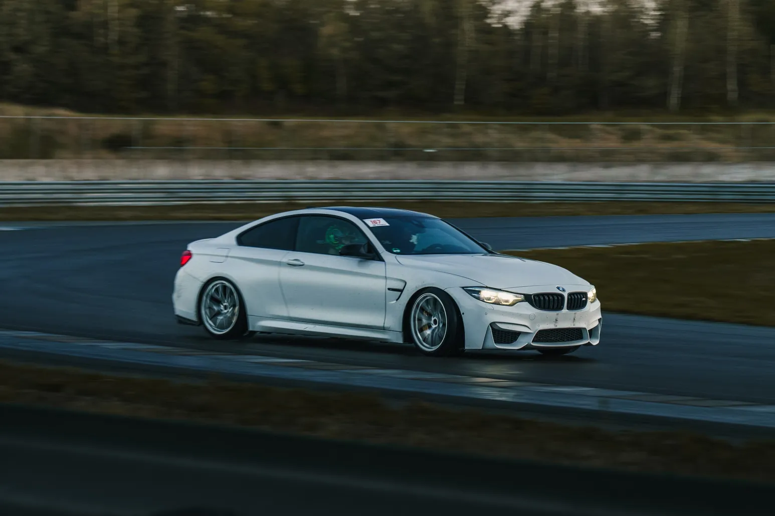 Weißer BMW M4 rutscht durch die Kurve