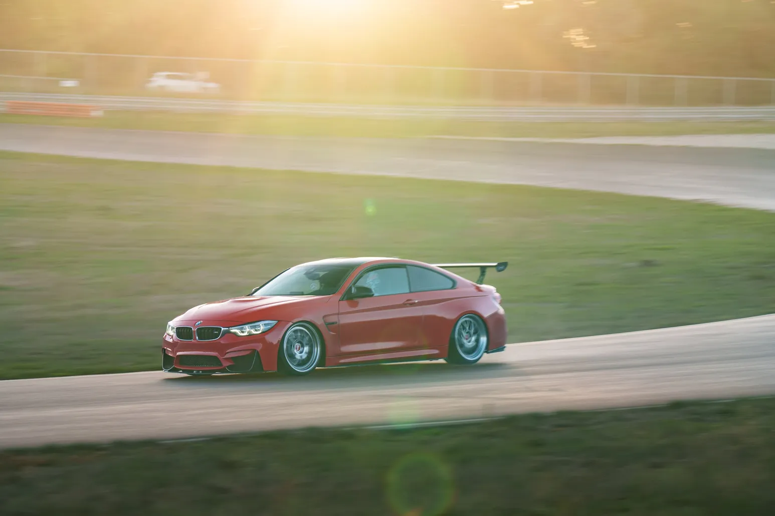 Roter BMW M4 im goldenen Gegenlicht auf der Strecke