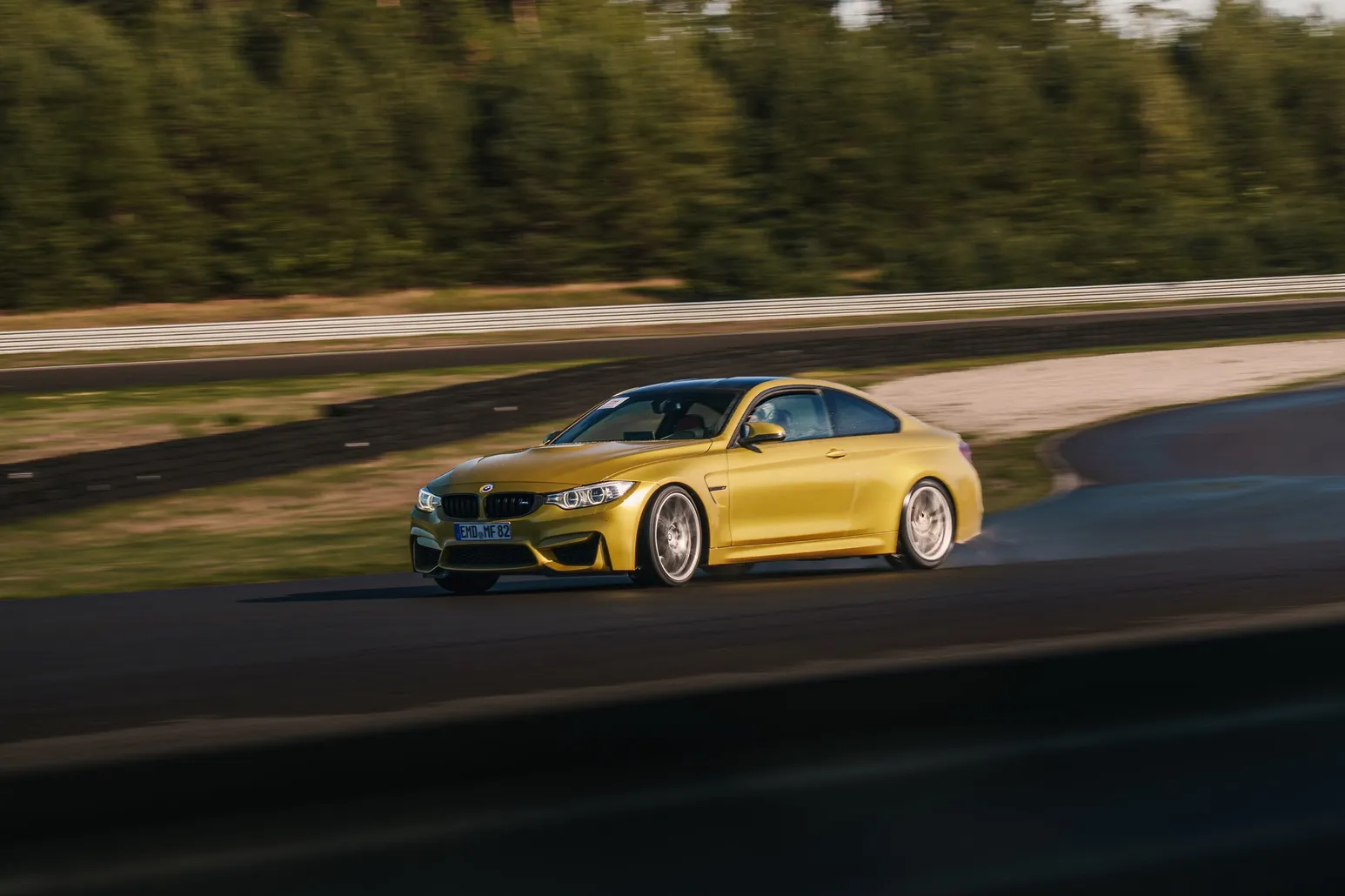 Gelber BMW M4 driftet in der tiefen Abendsonne