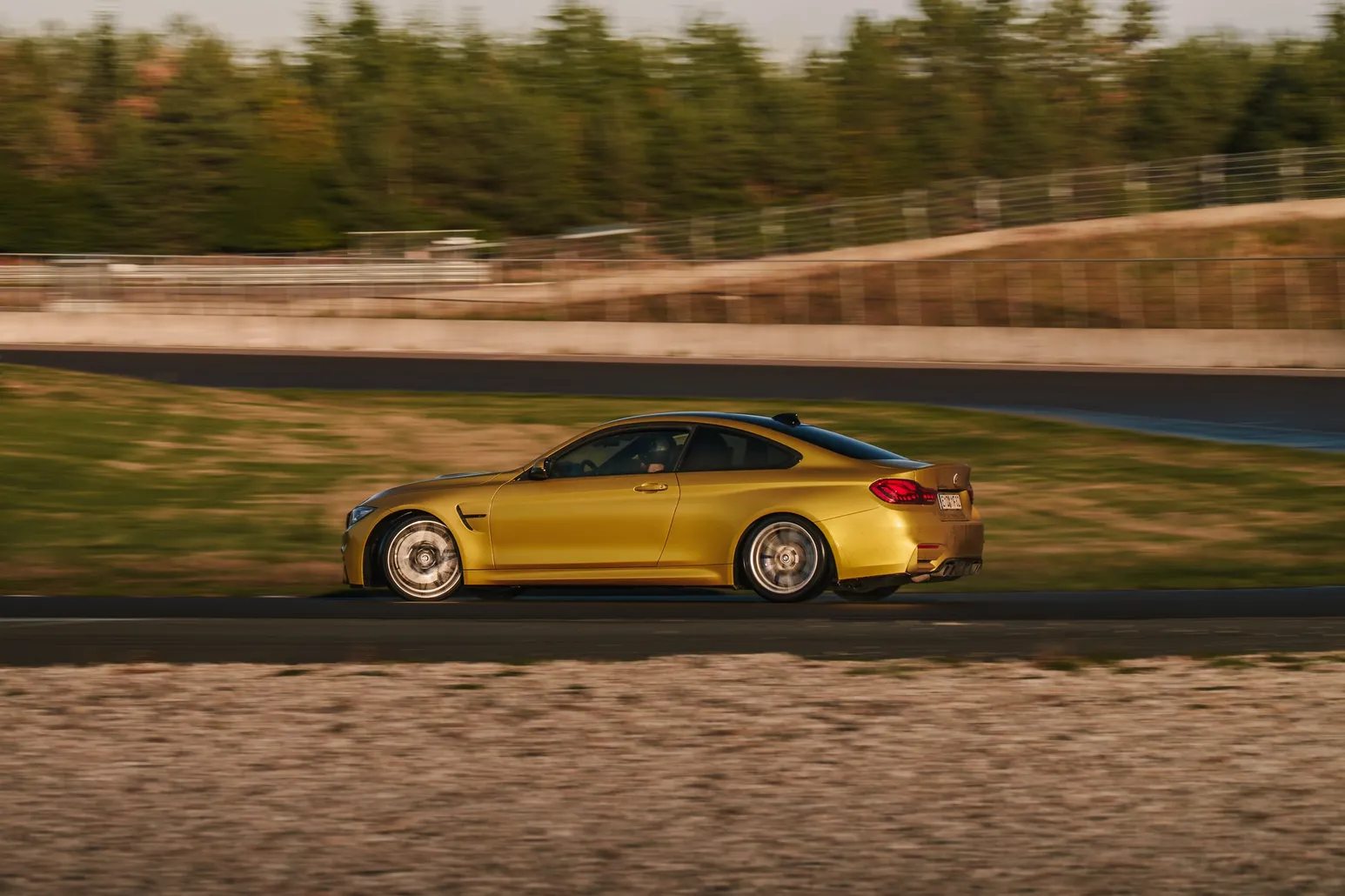 Gelber BMW M4 seitlich mit Bewegungsunschärfe