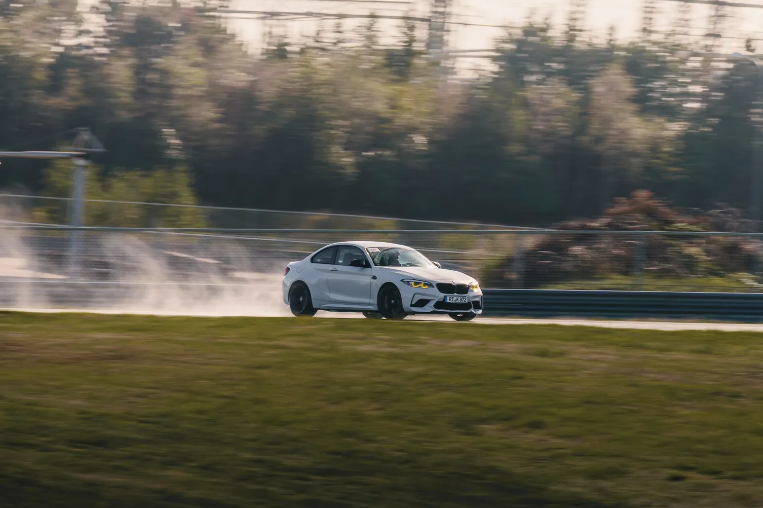 Weißer BMW M2 driftet mit Rauchfahne