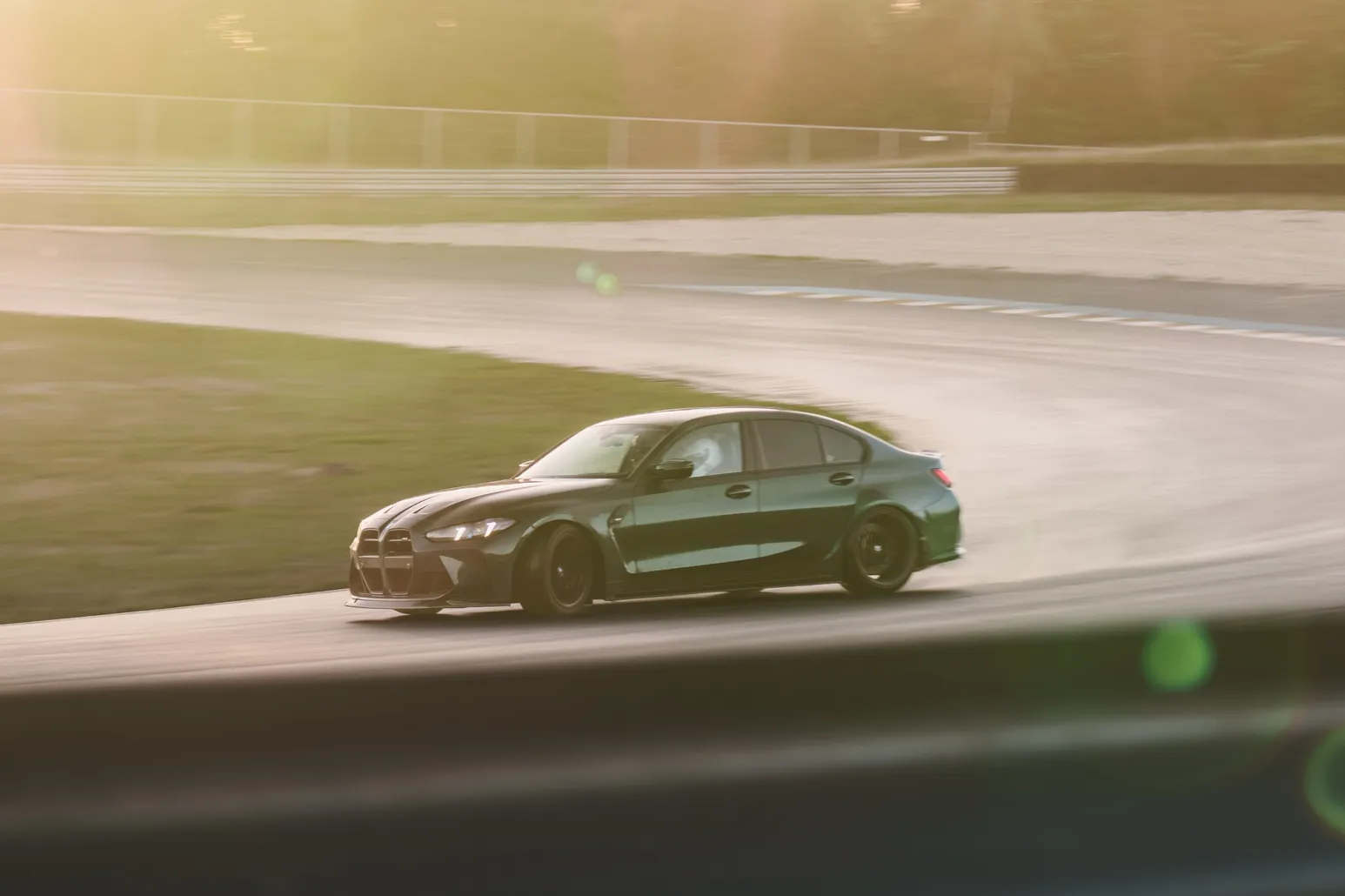 Grüner BMW M3 driftet durch Dunst und Gegenlicht