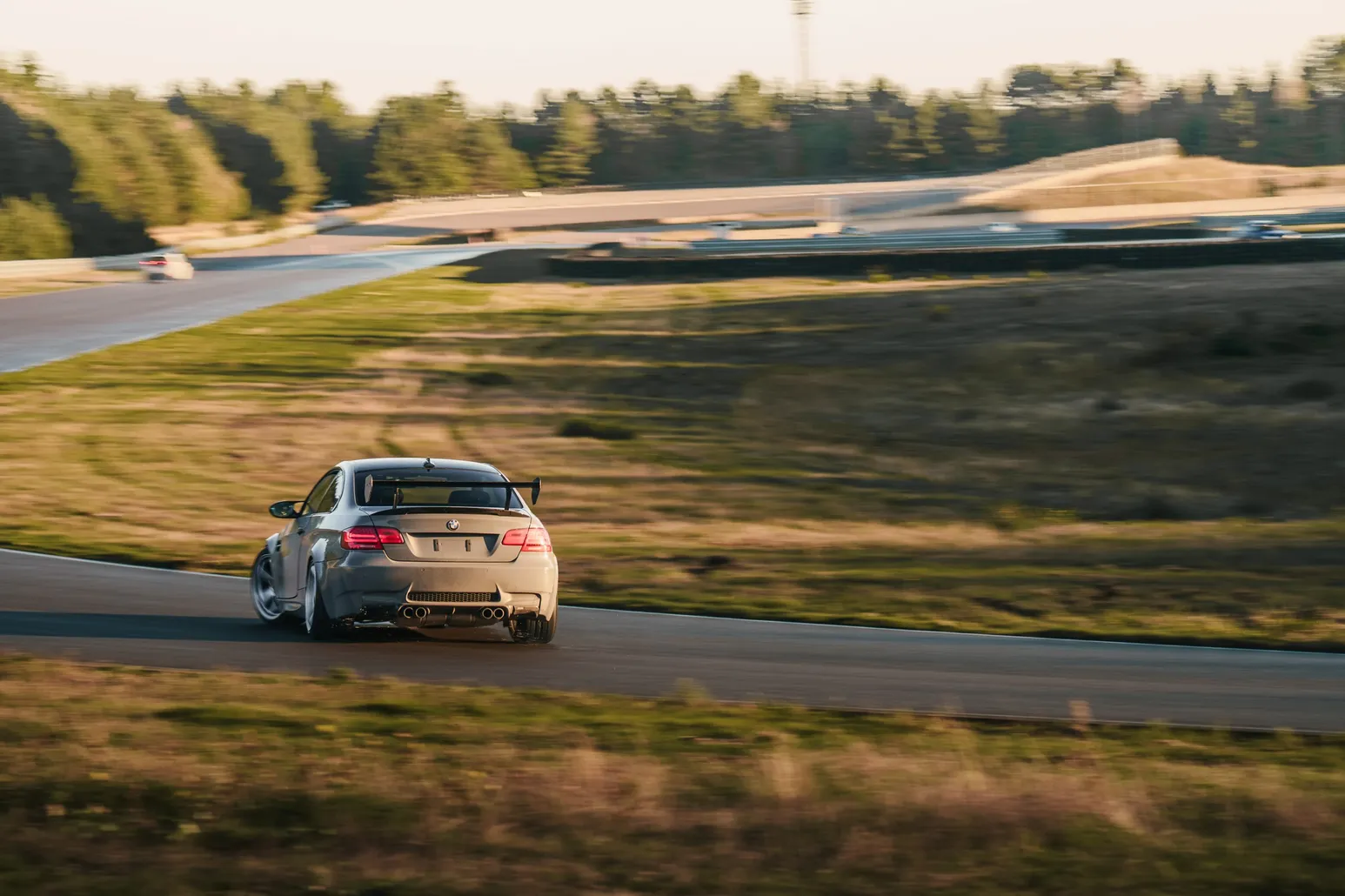 Grauer BMW driftet von der Kamera weg durch die Kurve