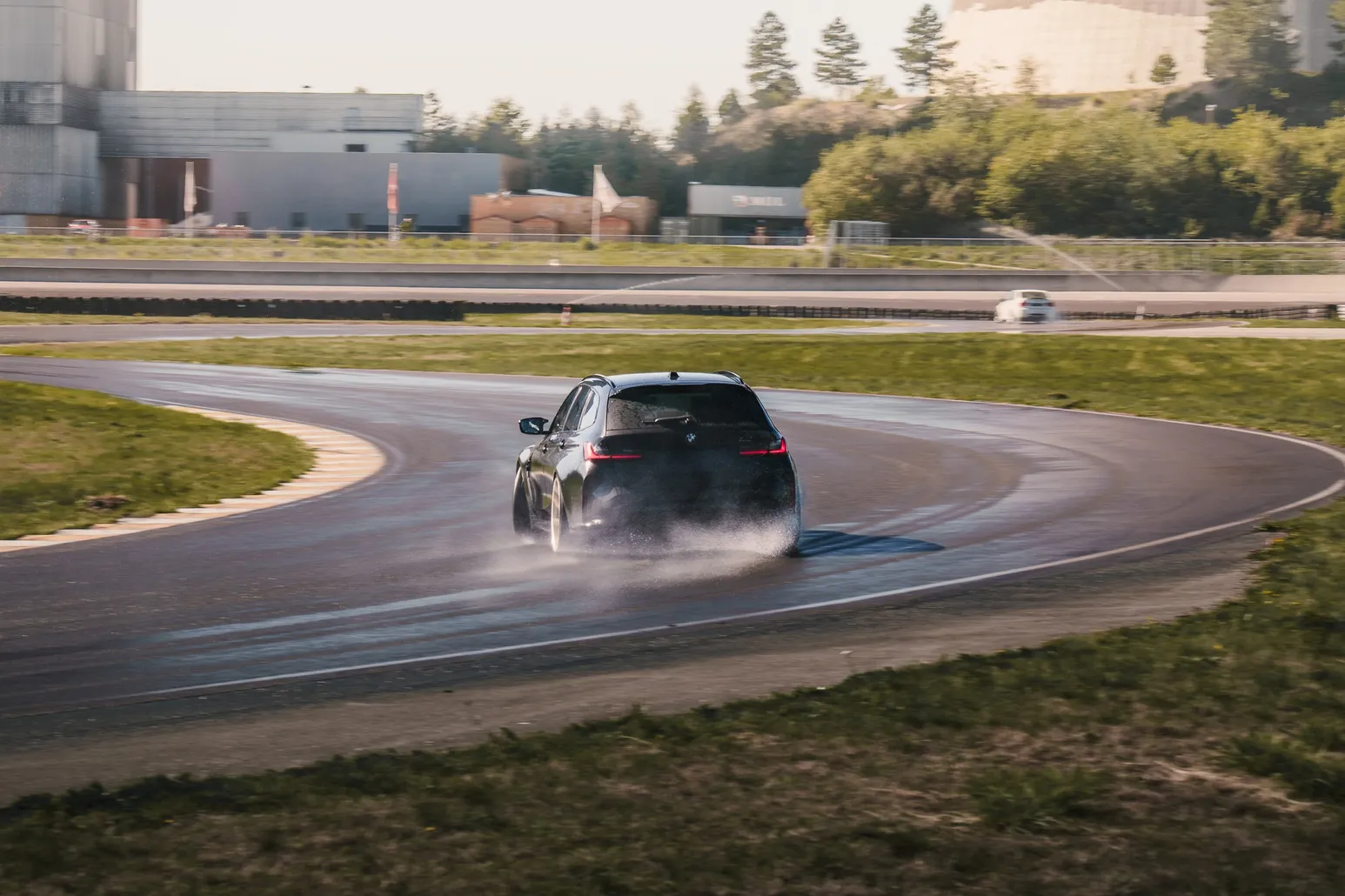 Dunkler BMW Touring driftet durch eine lange Kurve