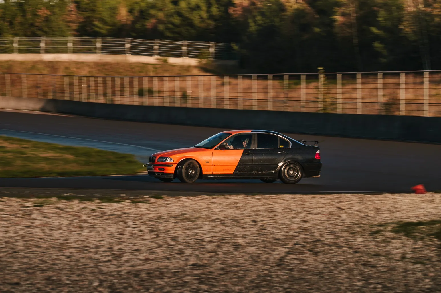 Orange-schwarzer BMW E46 rutscht an einem Pylon vorbei