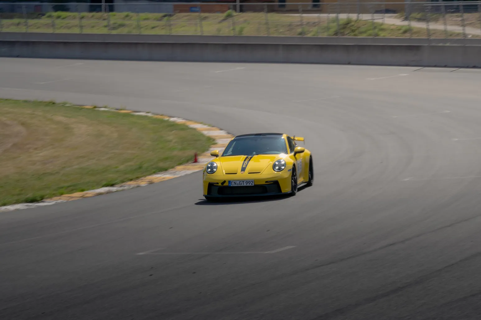 Gelber Porsche 911 GT3 beim Einlenken in eine Kurve