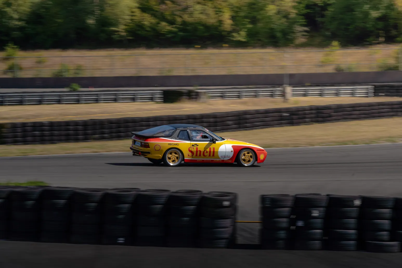 Porsche 944 im Shell-Design fährt an der Reifenstapel-Barriere vorbei