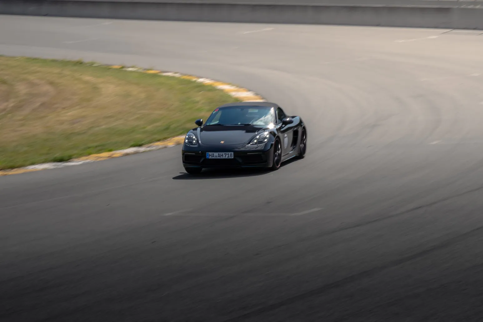 Schwarzer Porsche 718 in einer Kurve