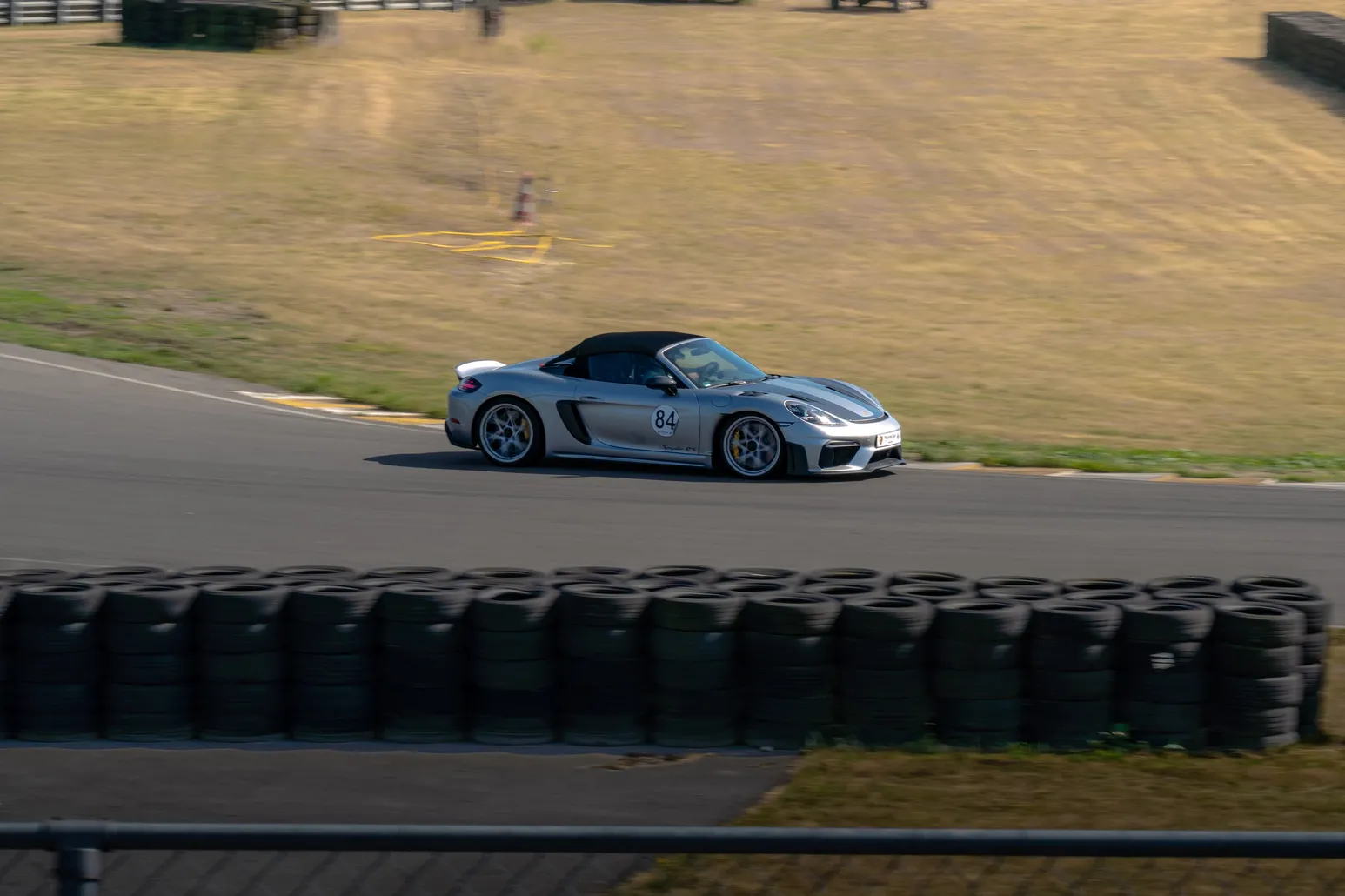 Silberner Porsche 718 Spyder an der Reifenbarriere