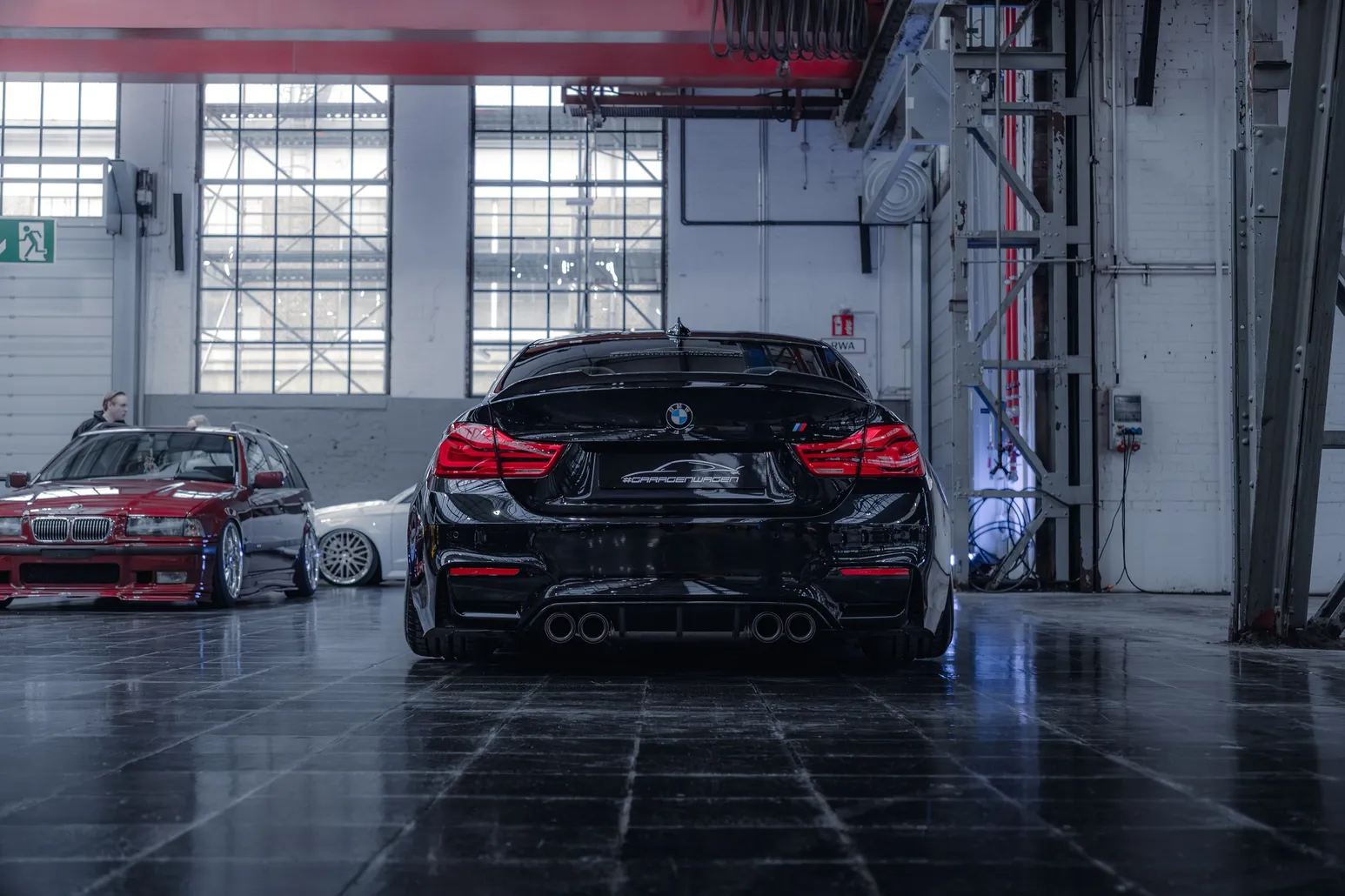 Black BMW M4 from behind in the exhibition hall