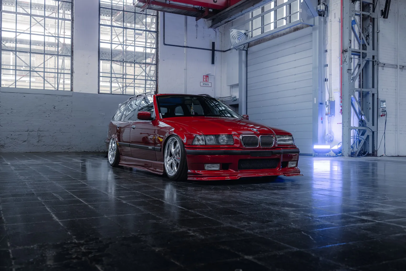 Red BMW E36 3 Series in the hall under skylights
