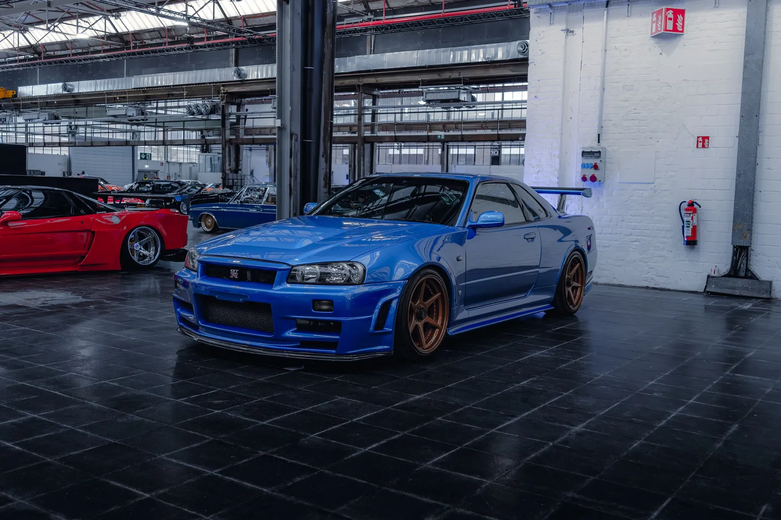 Blue Nissan Skyline R34 GT-R with bronze wheels