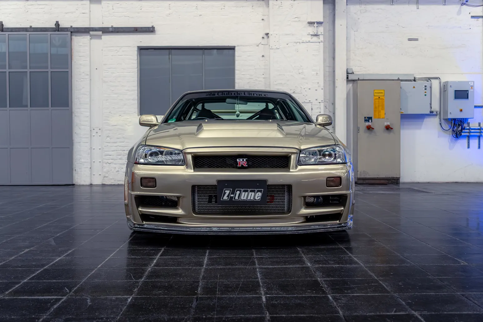 Nissan Skyline R34 Z-tune head-on against a white brick wall
