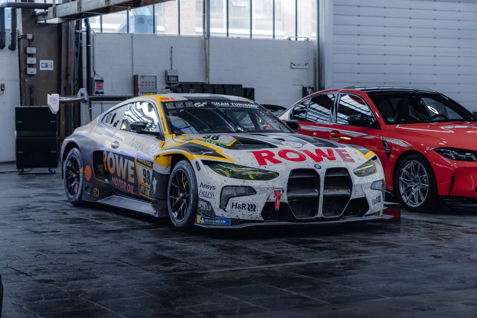 BMW M4 GT3 in ROWE livery next to a red BMW