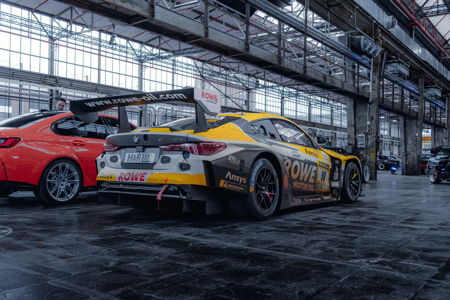 BMW M4 GT3 in ROWE livery side view with red cars
