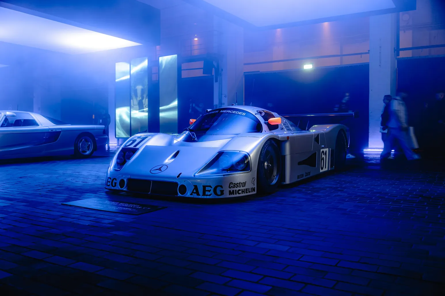 Silver Group C race car with AEG livery in blue haze